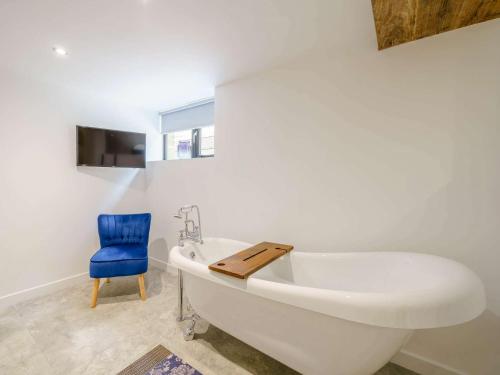 een badkamer met een wit bad en een blauwe stoel bij 3 Bed in Blackpool 41702 in Hambleton