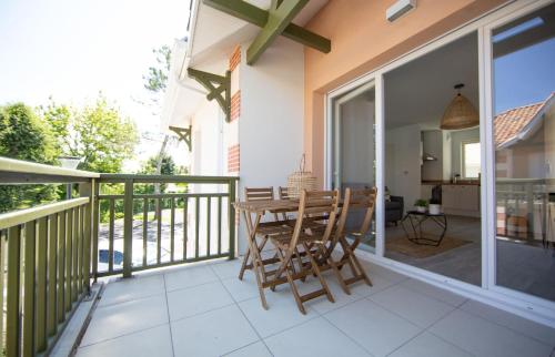 un patio con tavolo e sedie sul balcone. di APPARTEMENT Des Verdiers a Andernos-les-Bains