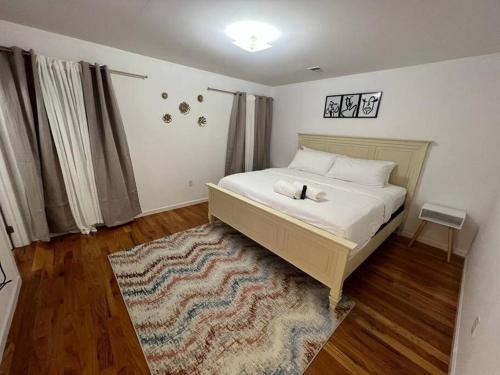 a bedroom with a bed and a rug on a wooden floor at NEwark Airport Elegant 3 Kings APT in Elizabeth