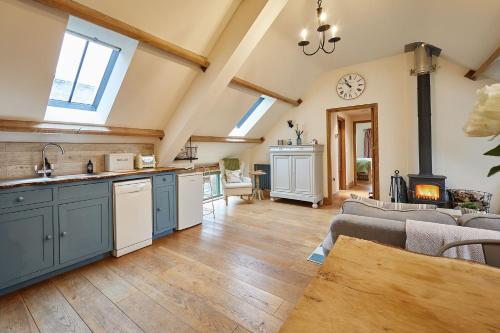 a kitchen with blue cabinets and a living room at Host & Stay - Llewenau Draw in Cwm-du