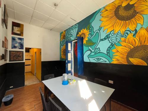 Lienzo Hostel and Mural Art Museum في بوبايان: غرفة بها لوحة جدارية لرواد الشمس على الحائط