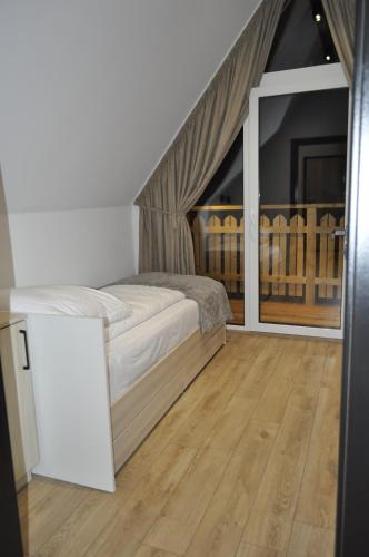 a bedroom with a bed and a large window at Leśny Zakątek in Poronin