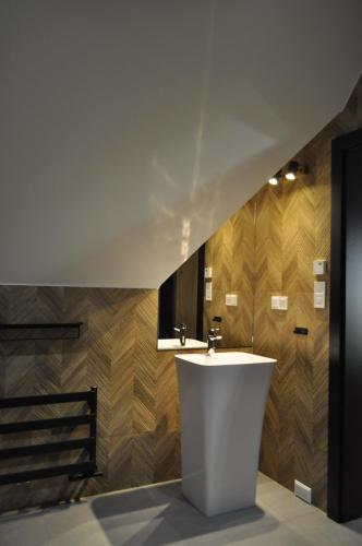 a bathroom with a white sink and wooden walls at Leśny Zakątek in Poronin