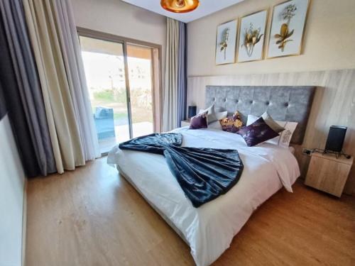 a bedroom with a large bed with a large window at Appartement de Luxe Prestigia in Marrakech