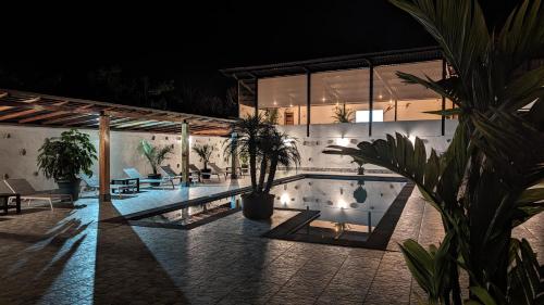 una casa con piscina por la noche en Las Terrazas de Dana Boutique Lodge & Spa, en Mindo