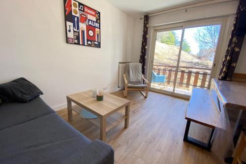 a living room with a couch and a table and a window at 06BD - Nice 6-person apartment facing the slopes in Péone
