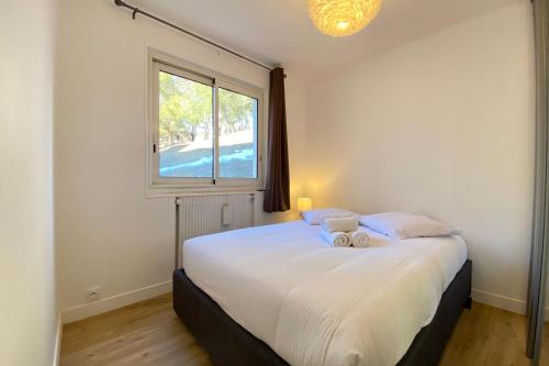 a bedroom with a large white bed with a window at 06BD - Nice 6-person apartment facing the slopes in Péone