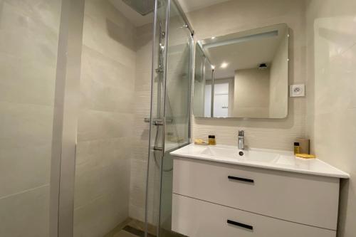uma casa de banho com um lavatório e um chuveiro com um espelho. em 06BD - Nice 6-person apartment facing the slopes em Péone