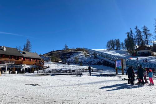 a group of people standing in the snow near a ski lodge at 06BD - Nice 6-person apartment facing the slopes in Péone