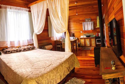 a bedroom with a bed in a wooden room at Boutique Bangalôs De São Chico in São Francisco de Paula