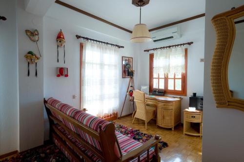 a living room with a couch and a desk at Archontiko Alexandros Luxury Suites in Kardiá