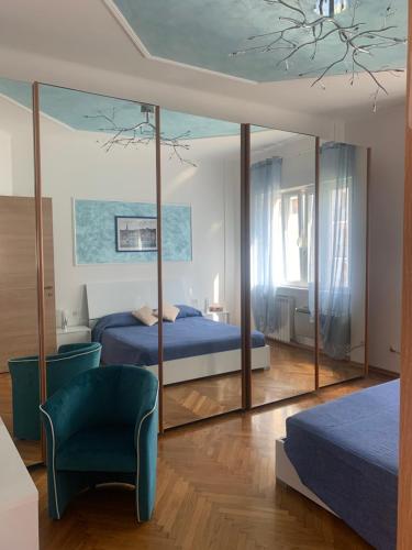 1 dormitorio con espejo, 1 cama y 1 silla en SoleMare Rooms Trieste en Trieste