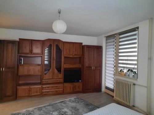 a living room with wooden cabinets and a large window at Apartment Lamele Bugojno in Bugojno