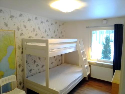 a white bunk bed in a room with a window at Havsnära villa in Nordmaling