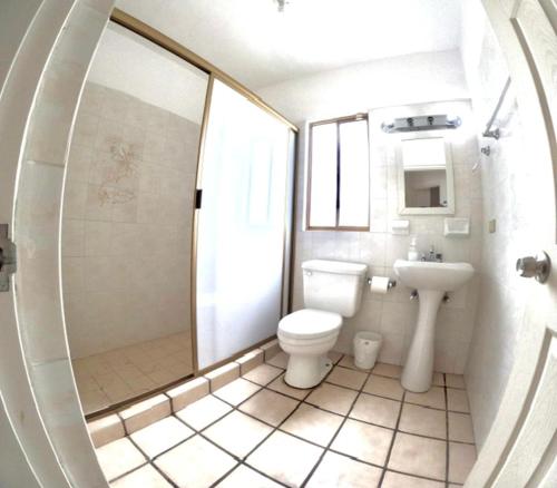 a white bathroom with a toilet and a sink at Vista al mar y alberca privada en Sector Bahía in San Carlos