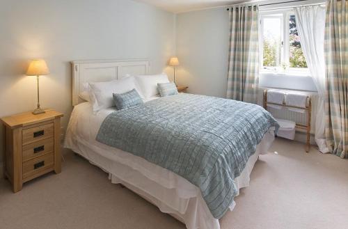 a bedroom with a large bed and a window at Coach House Barn in Cranleigh