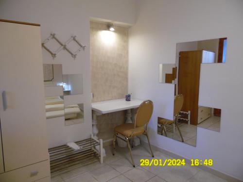 Zimmer mit einem Tisch, 2 Stühlen und einem Spiegel in der Unterkunft La Casa di Giuditta - B&B Casa Vacanze - Ramacca in Ramacca