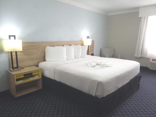 ein Hotelzimmer mit einem großen Bett und zwei Lampen in der Unterkunft Days Inn by Wyndham Dalhart in Dalhart