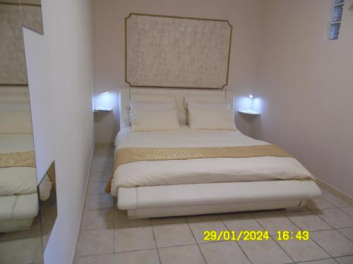 ein Schlafzimmer mit einem weißen Bett mit zwei Kissen in der Unterkunft La Casa di Giuditta - B&B Casa Vacanze - Ramacca in Ramacca