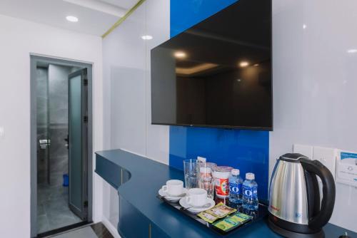 a bathroom with a blue counter with drinks on it at Arina Luxury Hotel - Vincom Tay Ninh in Tây Ninh