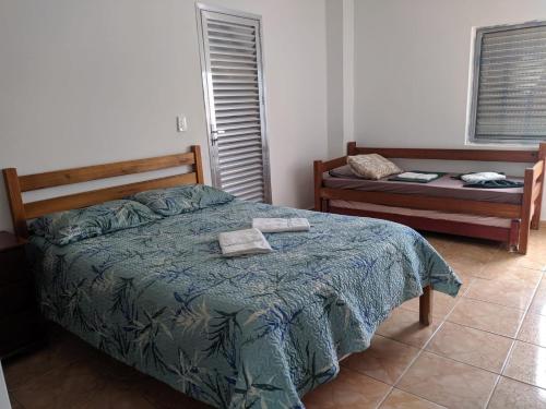 a bedroom with a bed with a blue comforter at Resort Saúde Premium in Peruíbe