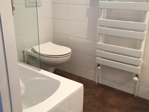 a white bathroom with a toilet and a sink at Appartement Huez, 1 pièce, 4 personnes - FR-1-405-228 in LʼHuez