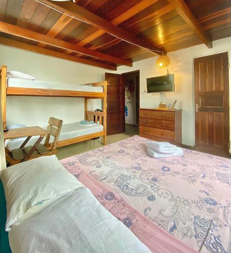 a bedroom with a large bed and bunk beds at CasAMARelo Hostel in Salvador