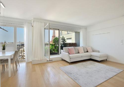 un salon avec un canapé blanc et une table dans l'établissement Top Floor Million Dollar View Eiffel Tower, 2 beds, 4 people, à Paris