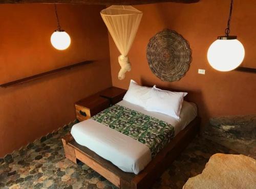 a bedroom with a bed in a room with two lights at REFUGIO LA ROCA in Los Santos