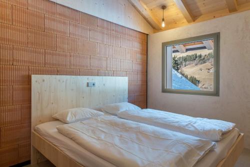 Bett in einem Zimmer mit einem Bild an der Wand in der Unterkunft Lena Dolomites Luxury Suite in Villnöß