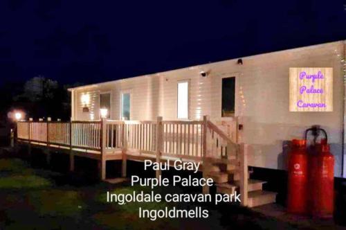 uma casa com um alpendre e um letreiro cor-de-rosa em Inviting beautiful 3-Bed Caravan in Ingoldmells em Ingoldmells