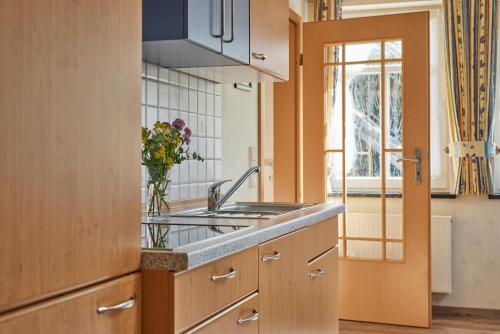 a kitchen with a sink and a vase of flowers at Pension und Ferienwohnung Schütte in Schmallenberg