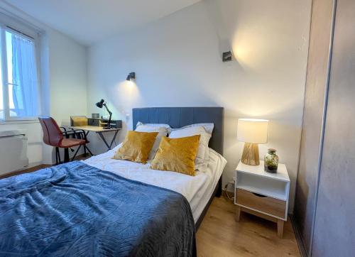 1 dormitorio con 1 cama y 1 mesa con silla en Meublé classé 3 étoiles Centre Ville de Céret, en Céret
