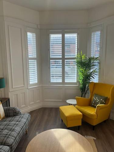 a living room with a yellow chair and a couch at Charming Victorian Terrace, South Belfast in Belfast