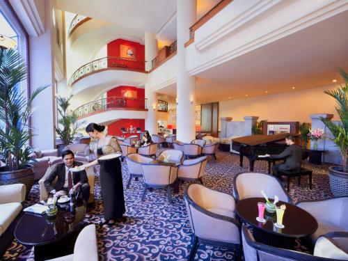 a hotel lobby with a man standing at a podium at Millennium Hotel Sirih Jakarta in Jakarta