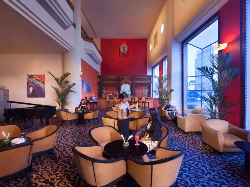a lobby with people sitting in chairs in a waiting room at Millennium Hotel Sirih Jakarta in Jakarta