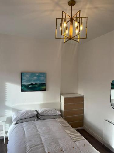 a bedroom with a bed and a chandelier at Charming Victorian Terrace, South Belfast in Belfast