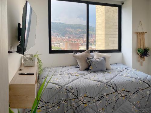 a bedroom with a bed and a large window at Moderno con vista, al lado de CC Mayorca y Metro in Sabaneta
