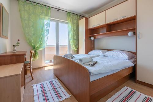 a bedroom with a bed and a large window at Apartments Ljiljana in Supetarska Draga