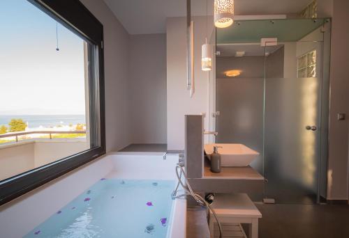 a bathroom with a bath tub and a sink at Bellevue Villas with private pool in Hanioti