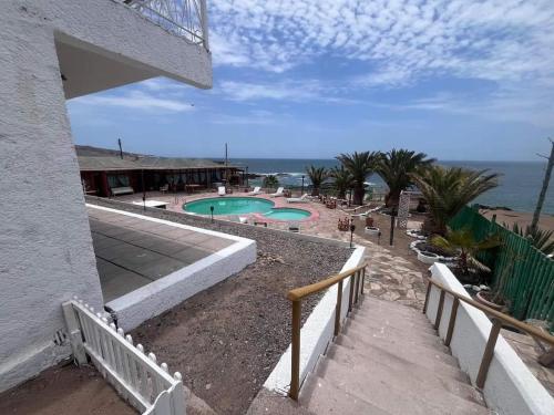 a resort with a swimming pool and the ocean at Hotel Josefina in Alto Hospicio