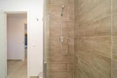 una ducha con puerta de cristal en un baño en Luna, en San Juan de los Terreros