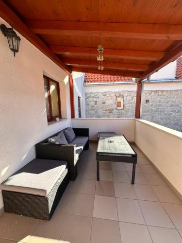 - un balcon avec deux canapés et une table dans l'établissement Apartman Lana, à Kaštela