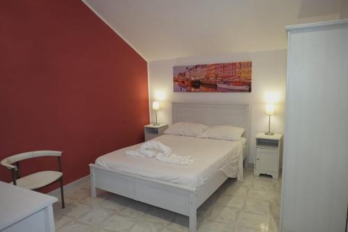 Un dormitorio con una cama blanca y una pintura en la pared en Il tugurio, en Vietri