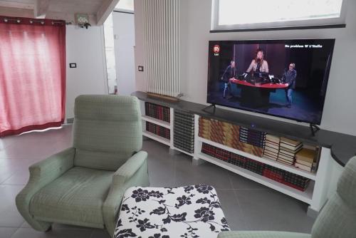 sala de estar con TV de pantalla plana y sillas en Il tugurio, en Vietri