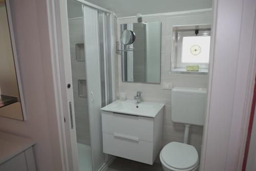 Baño blanco con lavabo y aseo en Il tugurio, en Vietri