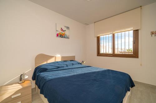 a bedroom with a blue bed and a window at Casa Musica in San Juan de los Terreros