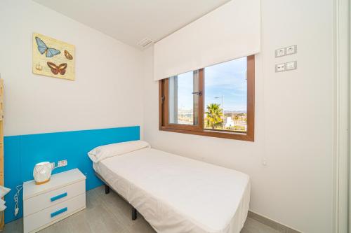 a small bedroom with a bed and a window at Casa Musica in San Juan de los Terreros