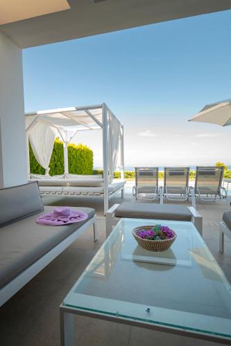 a living room with a glass table and chairs at Bellevue Villas with private pool in Hanioti