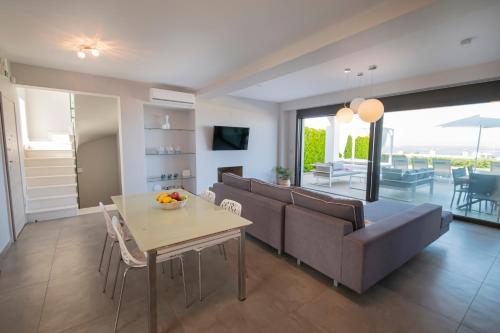 a living room with a couch and a table at Bellevue Villas with private pool in Hanioti